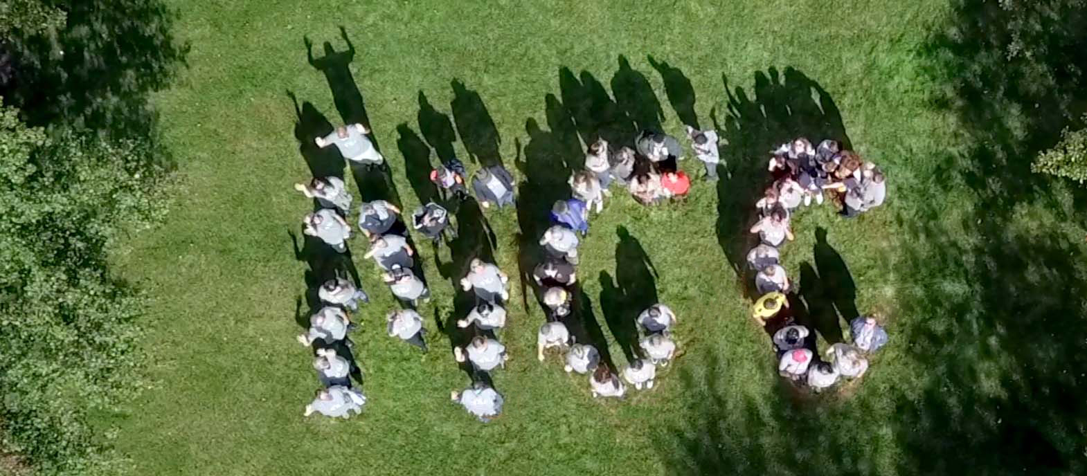 Employees, students, and community spell out 100 on the grass 